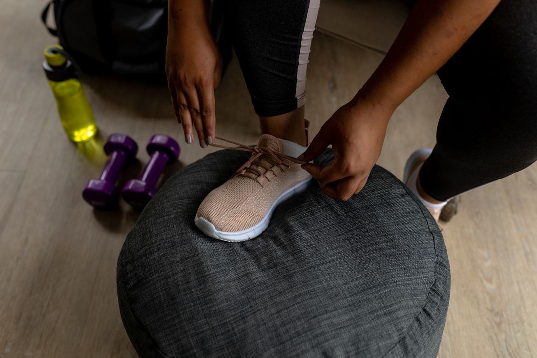 African American Woman Tying Shoelace Before Workout - Free Images, Stock Photos and Pictures on Pikwizard.com