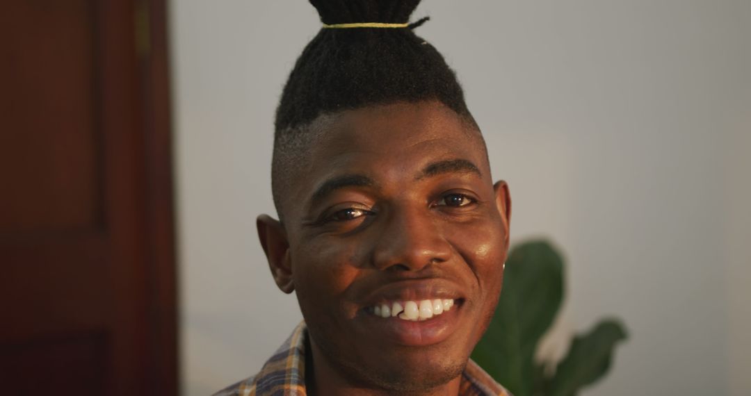 Confident Smiling Man with Stylish Updo in Cozy Home