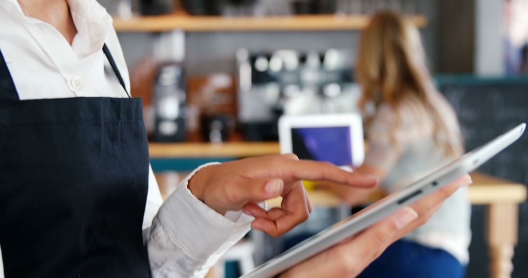 Waitress Using Tablet in Café for Efficient Ordering