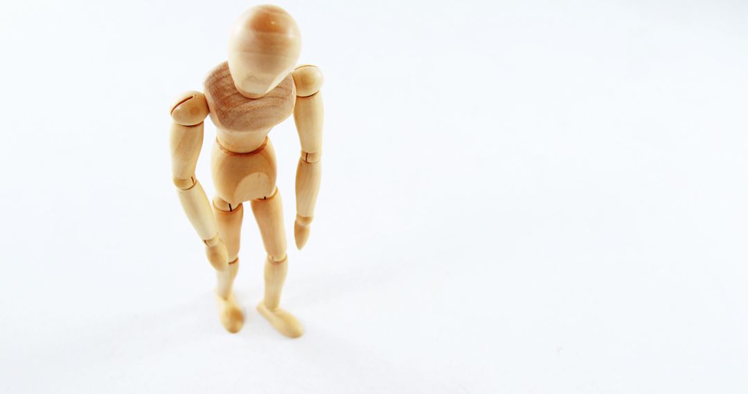 Wooden Figure Model in Contemplative Pose on White Background - Free Images, Stock Photos and Pictures on Pikwizard.com