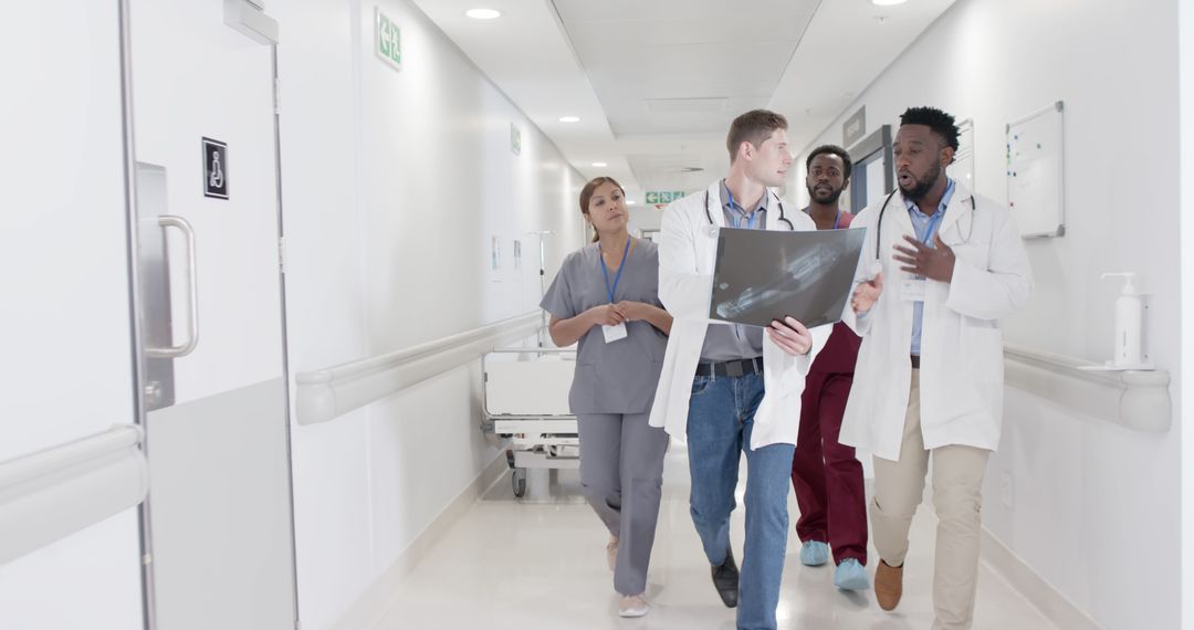 Medical Team Discussing Patient X-ray in Hospital Corridor - Free Images, Stock Photos and Pictures on Pikwizard.com