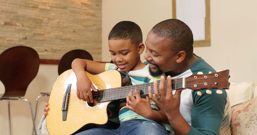 Father and Son Playing Guitar Together at Home - Free Images, Stock Photos and Pictures on Pikwizard.com