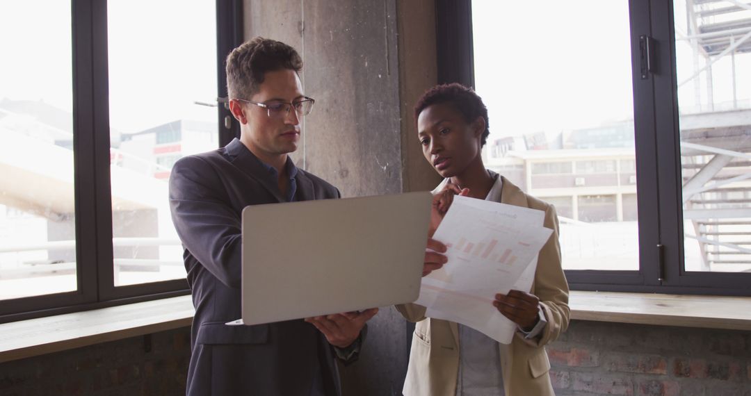 Business Colleagues Reviewing Data in Modern Cafe Setting