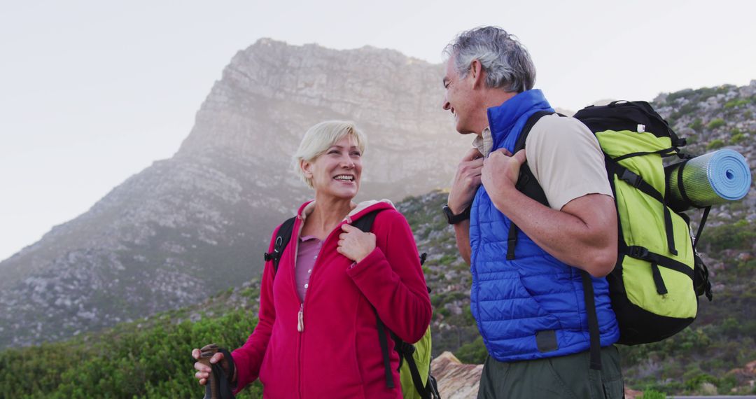 Senior Couple Smiling While Hiking in Mountain Landscape - Free Images, Stock Photos and Pictures on Pikwizard.com