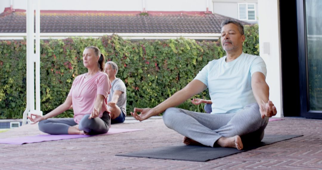 Meditation Session on Outdoor Patio with Senior Practitioners in Serene Yoga Poses