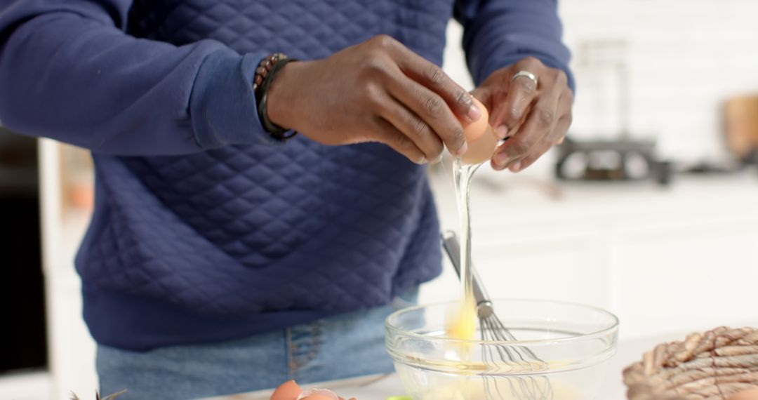African American Man Cracking Egg in Modern Kitchen Setting