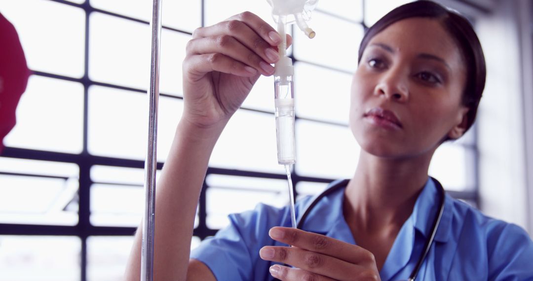 Focused Nurse Adjusting Intravenous Drip - Free Images, Stock Photos and Pictures on Pikwizard.com