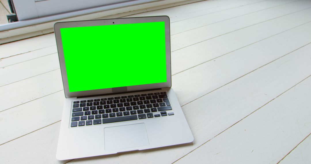 Laptop on Wooden Floor with Green Screen Display in Home Setting - Free Images, Stock Photos and Pictures on Pikwizard.com