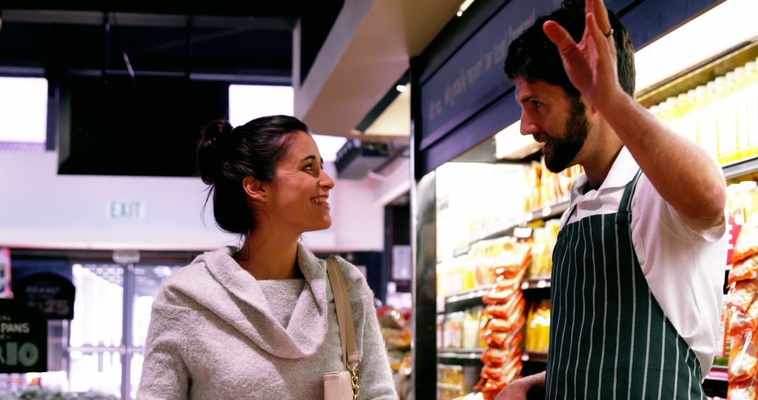 Smiling Woman Engaging with Store Clerk in Grocery Aisle - Free Images, Stock Photos and Pictures on Pikwizard.com