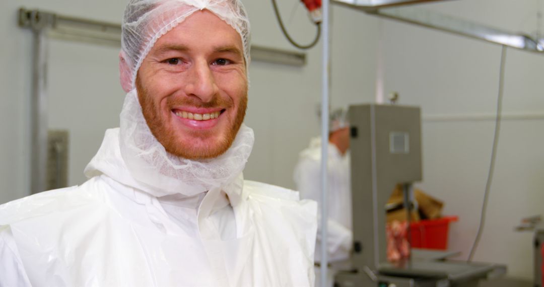 Smiling Worker in Meat Processing Plant Wearing White Safety Gear - Free Images, Stock Photos and Pictures on Pikwizard.com