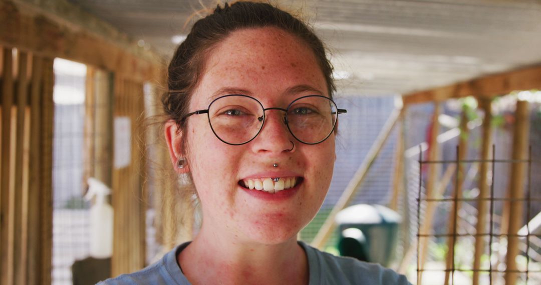 Smiling Woman with Glasses and Piercings in Outdoor Sheltered Area - Free Images, Stock Photos and Pictures on Pikwizard.com