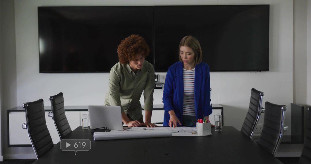 Business Architects Collaborating over Blueprints in Modern Boardroom with Laptop Screens
