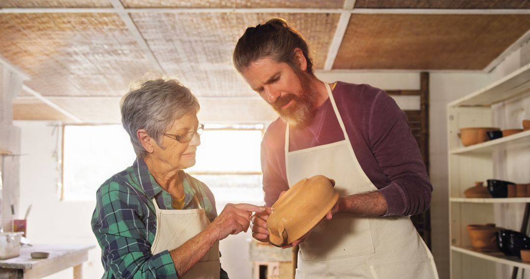 Older Woman Teaching Pottery to Middle-aged Man in Workshop - Free Images, Stock Photos and Pictures on Pikwizard.com