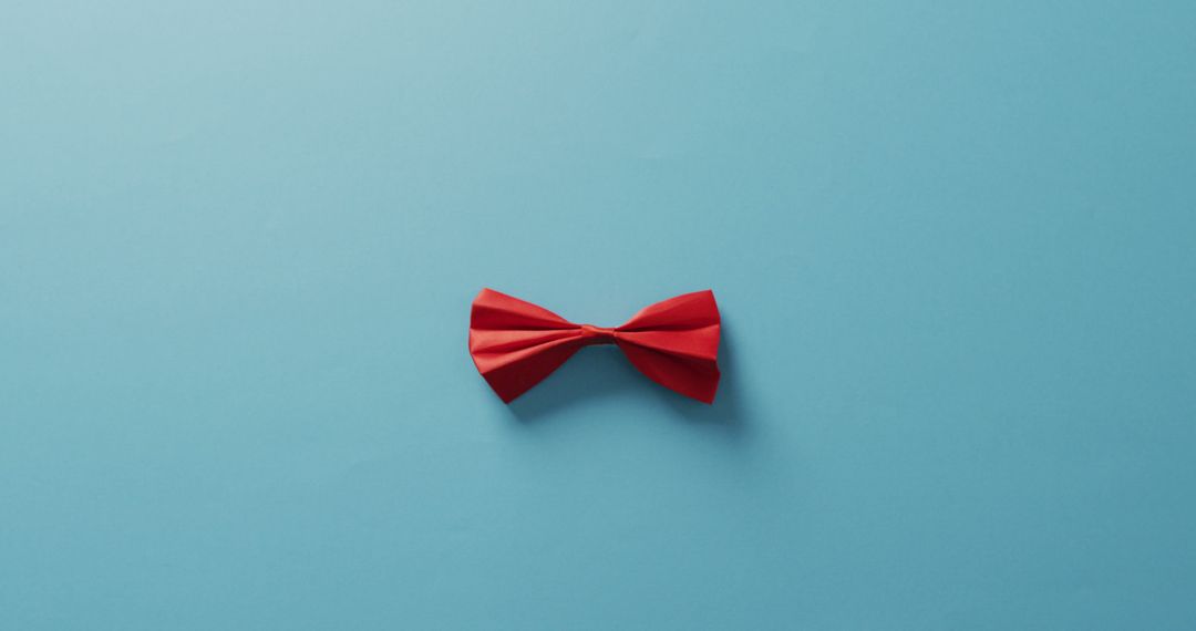 Minimalistic Red Bow Tie on Blue Background - Free Images, Stock Photos and Pictures on Pikwizard.com
