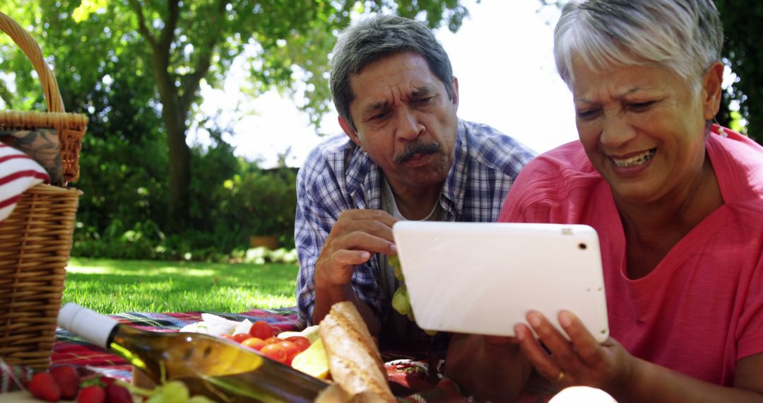 Middle-Aged Latino Couple Enjoys Picnic with Technology