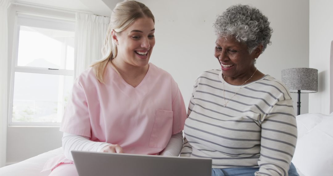 Healthcare Worker Assisting Elderly Woman with Laptop in Bright Room - Free Images, Stock Photos and Pictures on Pikwizard.com