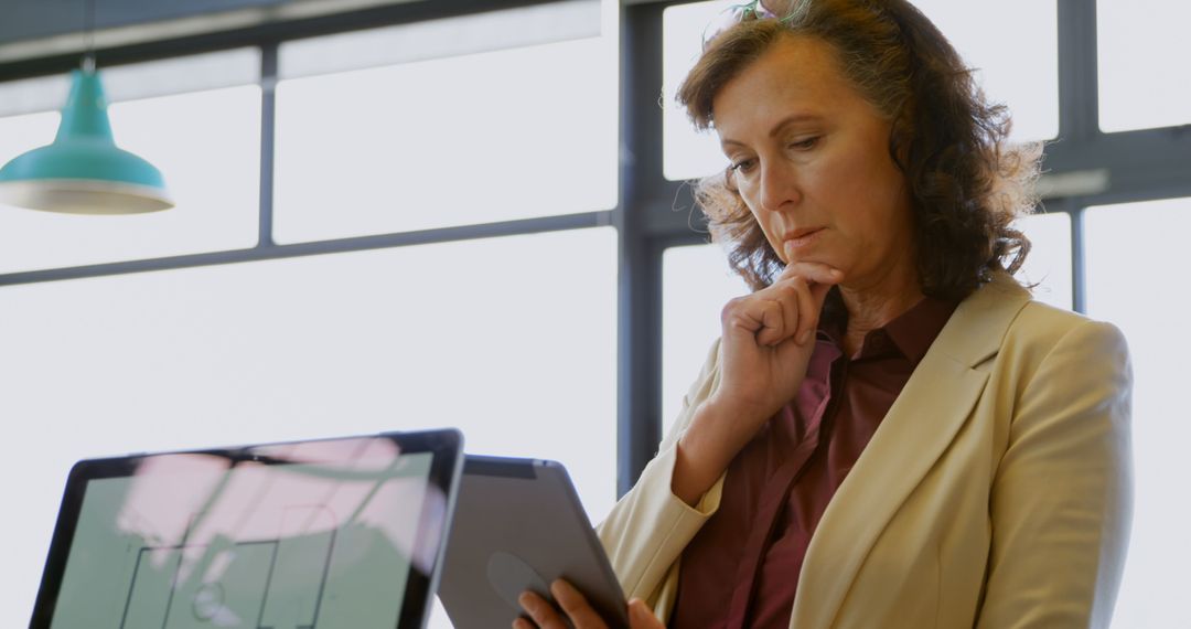 Thoughtful Businesswoman Analyzing Data on Tablet in Office