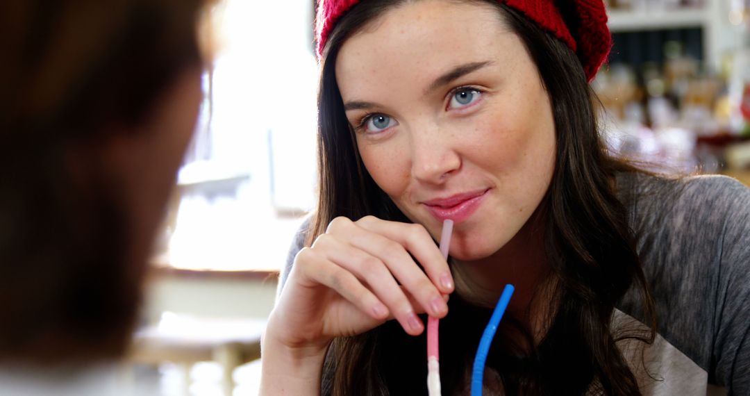 Woman Drinking Beverage with Straw in Cozy Cafe - Free Images, Stock Photos and Pictures on Pikwizard.com