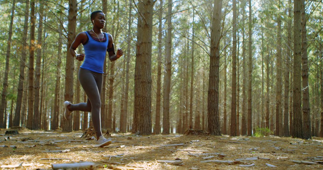 African American woman jogging in pine forest for exercise - Free Images, Stock Photos and Pictures on Pikwizard.com