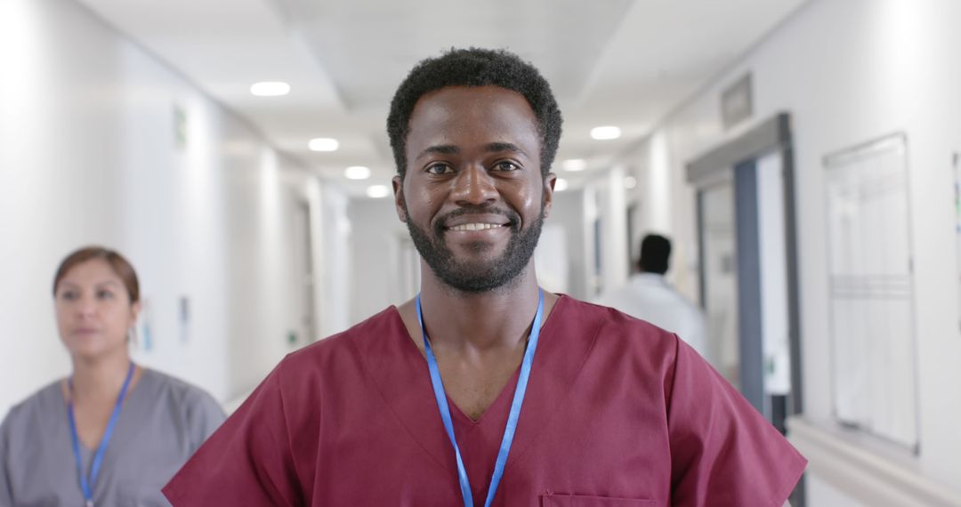 Confident Young African American Male Nurse Smiling in Hospital Corridor - Free Images, Stock Photos and Pictures on Pikwizard.com