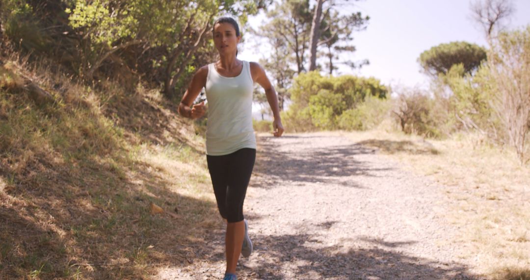 Smiling woman jogging in forest - Free Images, Stock Photos and Pictures on Pikwizard.com