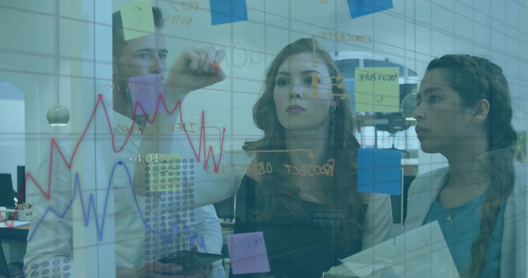 Team collaborating and drawing analytics on glass board with sticky notes in modern office