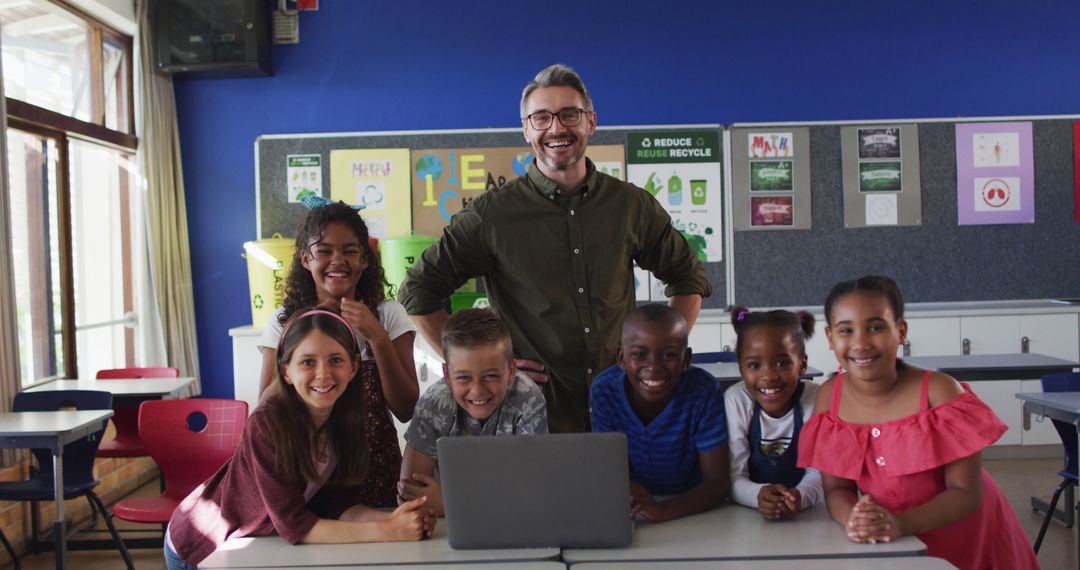 Portrait of happy diverse male teacher and group of schoolchildren looking at laptop - Free Images, Stock Photos and Pictures on Pikwizard.com