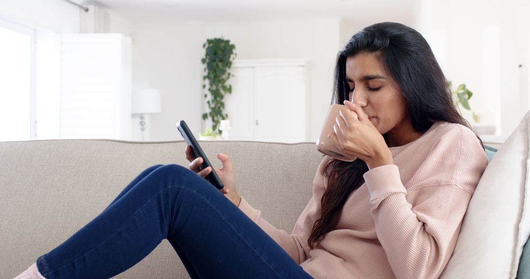Woman Relaxing with Coffee and Smartphone on Modern Couch