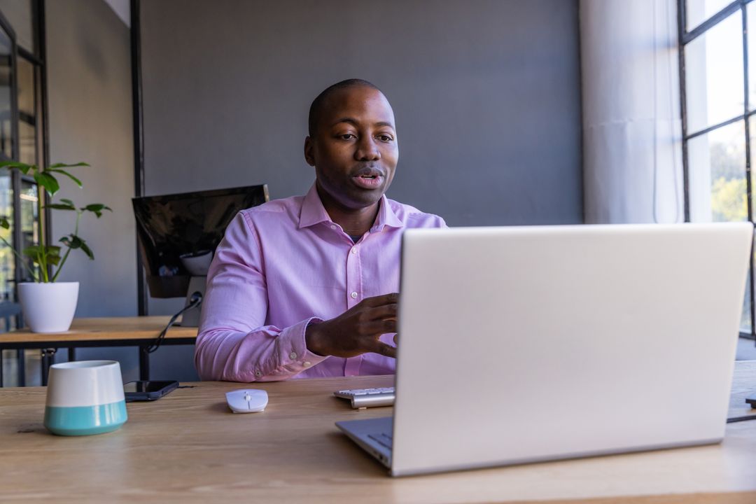 Focused Professional Man Typing on Laptop in Modern Office