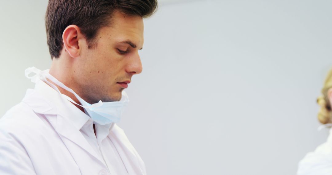 Young Male Doctor in Medical Uniform Focused on Work - Free Images, Stock Photos and Pictures on Pikwizard.com