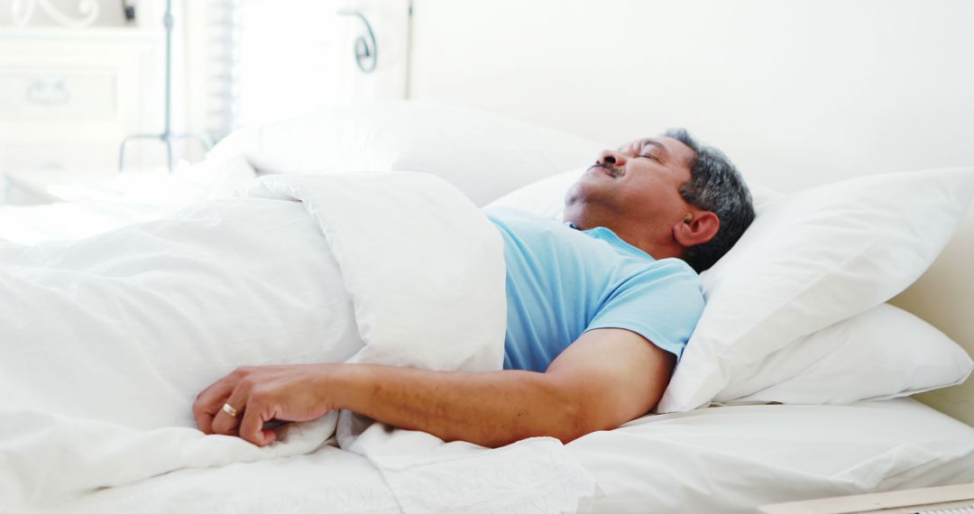 Elderly Man Sleeping Peacefully on Comfortable Bed in Morning Light - Free Images, Stock Photos and Pictures on Pikwizard.com