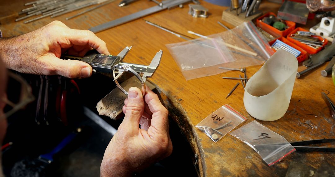 Jeweler using precision caliper measuring silver ring in workshop - Free Images, Stock Photos and Pictures on Pikwizard.com