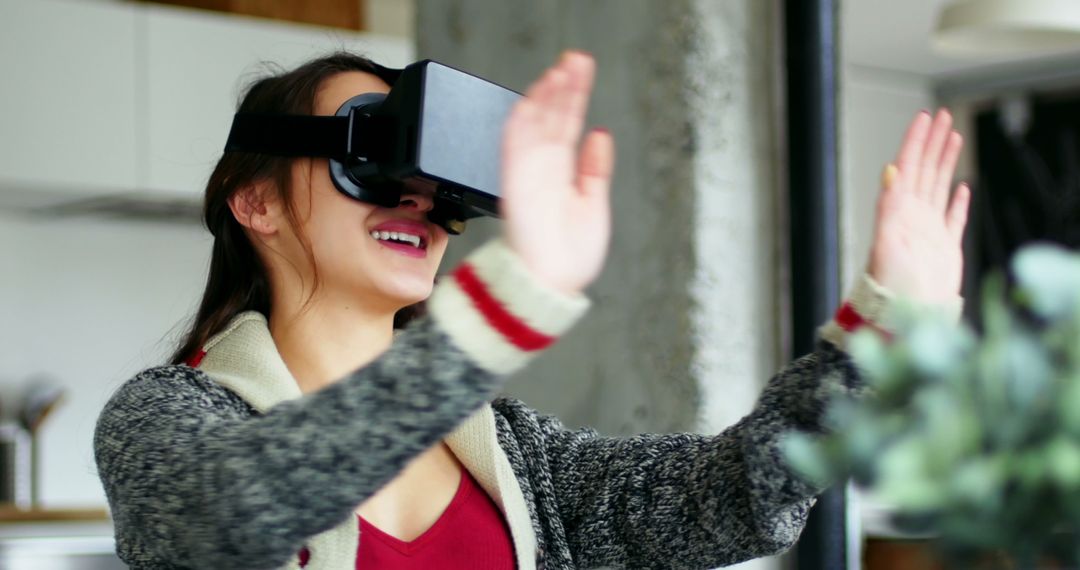 Enthusiastic Woman Using Virtual Reality Headset for Immersive Experience at Home - Free Images, Stock Photos and Pictures on Pikwizard.com