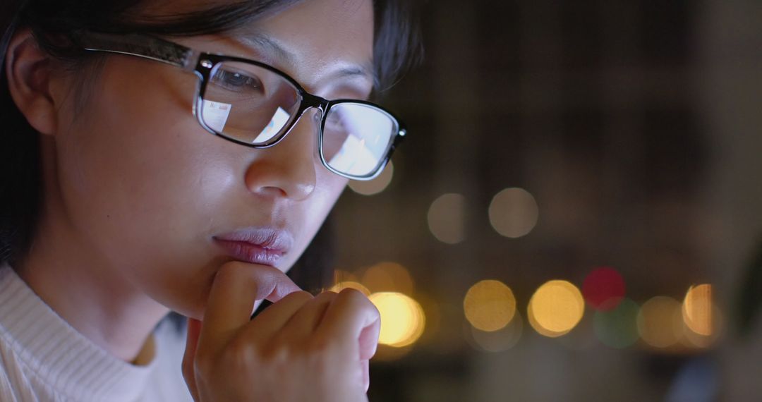 Young woman in glasses working at night with focus and determination - Free Images, Stock Photos and Pictures on Pikwizard.com