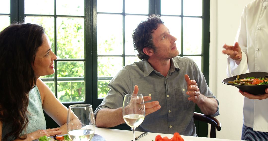 Couple Conversing with Chef in Elegant Restaurant Setting