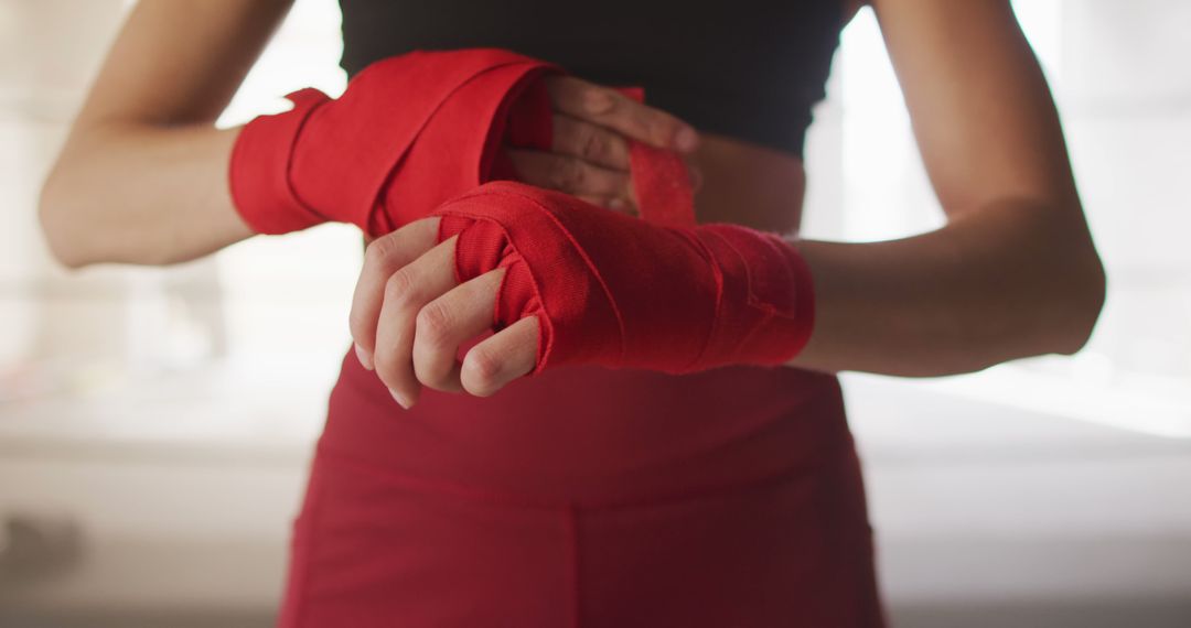 Person Wrapping Hands with Red Tape Before Workout - Free Images, Stock Photos and Pictures on Pikwizard.com