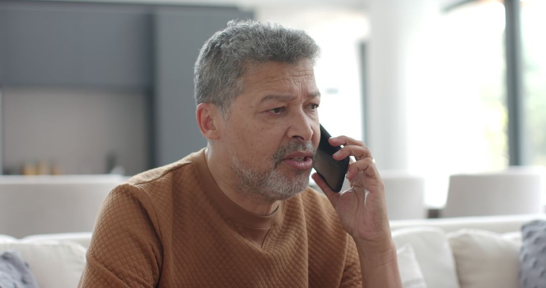 Middle-aged man having serious phone conversation at home - Free Images, Stock Photos and Pictures on Pikwizard.com