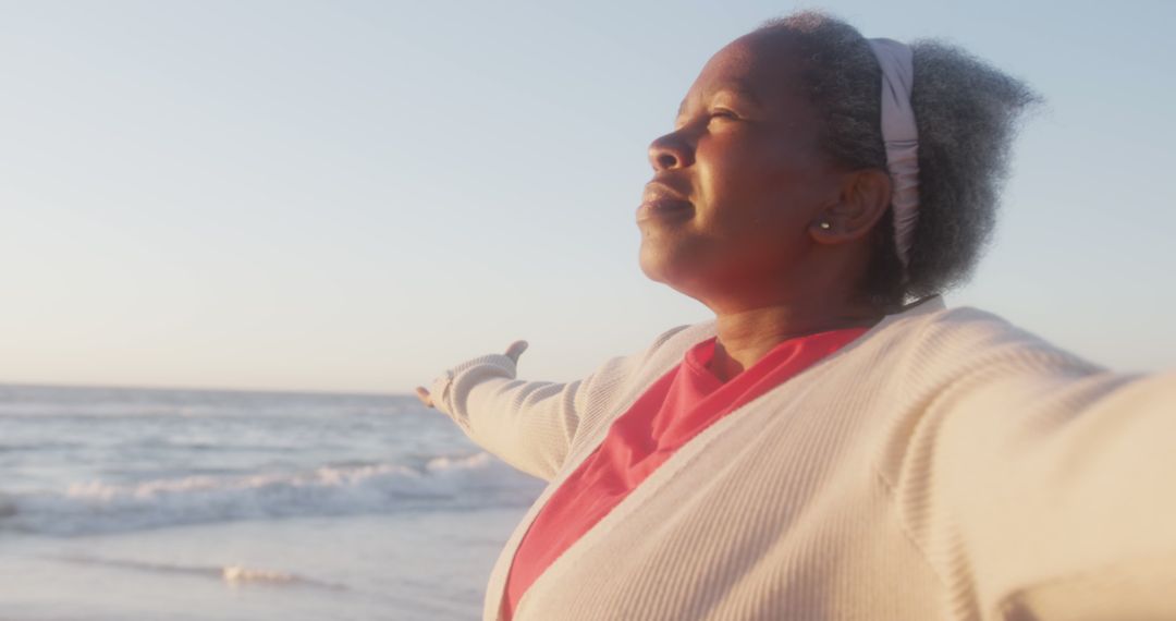 Happy Senior Woman Enjoying Beach Sunset with Open Arms - Free Images, Stock Photos and Pictures on Pikwizard.com