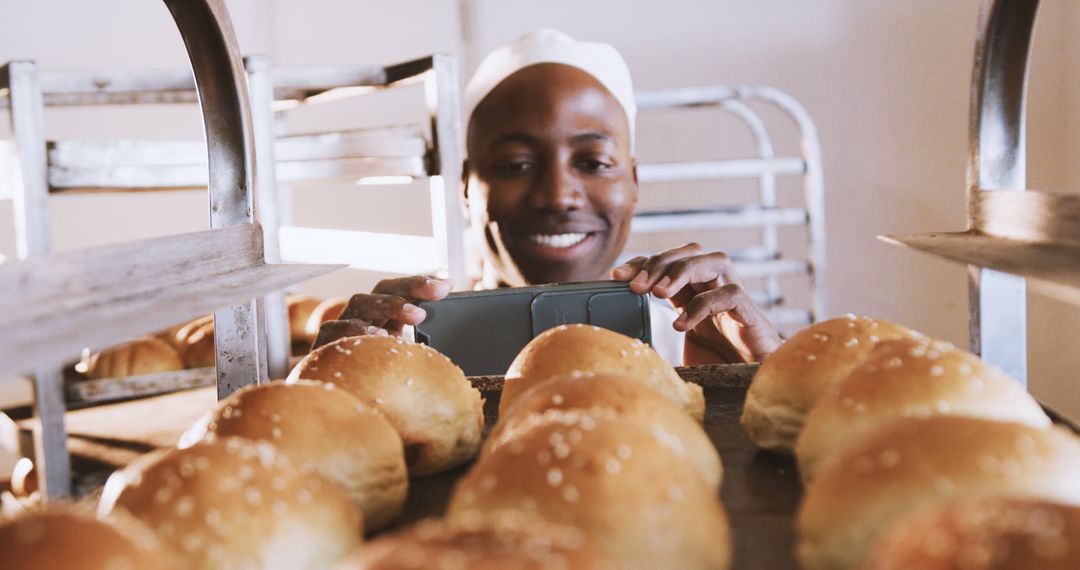 Smiling Baker Taking Photo of Freshly Baked Bread Rolls in Bakery - Free Images, Stock Photos and Pictures on Pikwizard.com