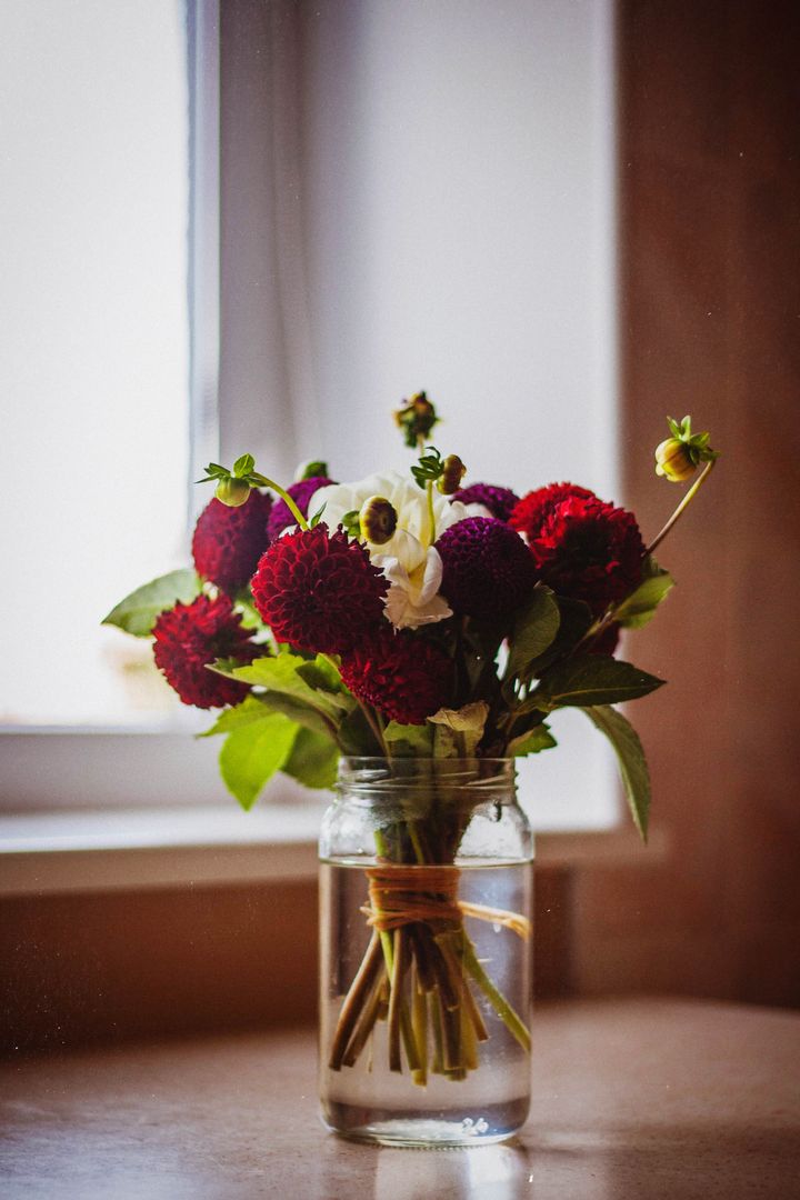 Rustic Mason Jar Bouquet with Deep Red Dahlias White Ranunculus Tied Stems on Windowsill