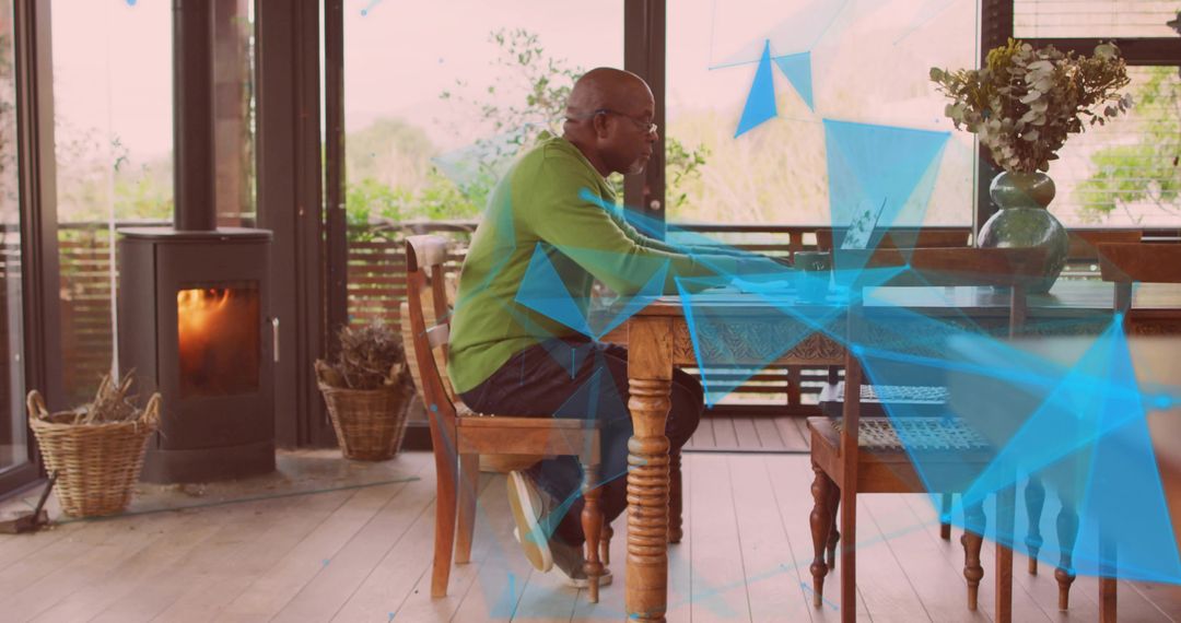 Man Working on Laptop in Sunlit Rustic Room with Stove