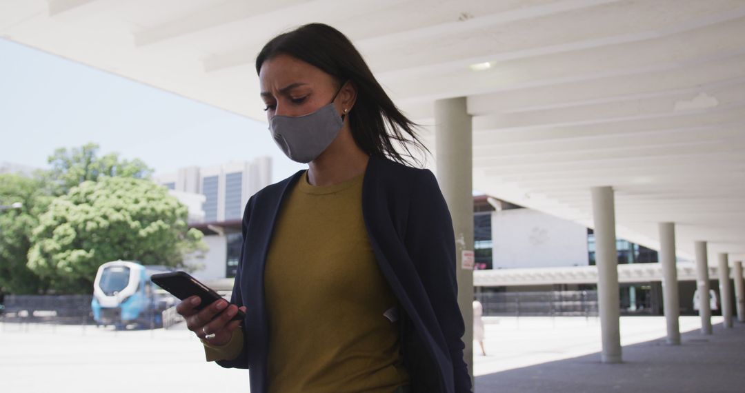 Businesswoman Wearing Face Mask Checking Phone Outdoors - Free Images, Stock Photos and Pictures on Pikwizard.com