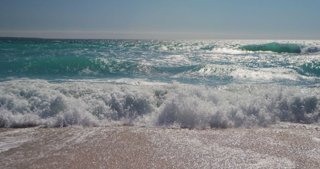 Waves Crashing on Sandy Beach under Bright Blue Sky - Free Images, Stock Photos and Pictures on Pikwizard.com