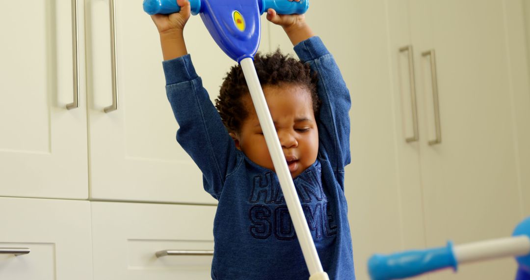 African American Toddler Playing with Toy Mop in Kitchen - Free Images, Stock Photos and Pictures on Pikwizard.com