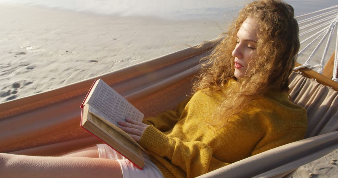 Young woman relaxing on beach hammock reading book - Free Images, Stock Photos and Pictures on Pikwizard.com