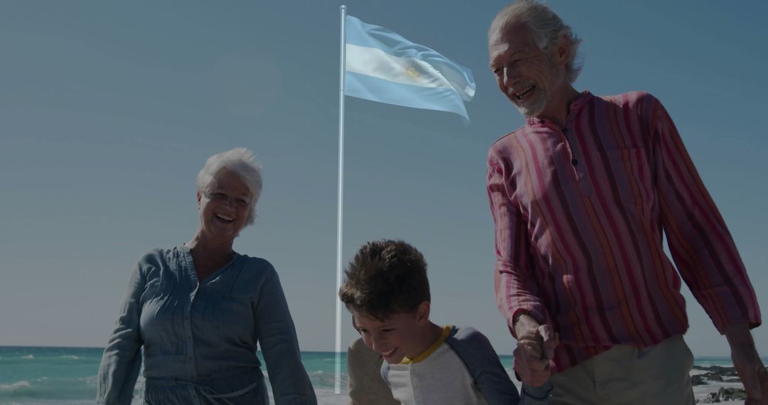 Elderly Couple and Grandchild Ambling Along Beach with Flag