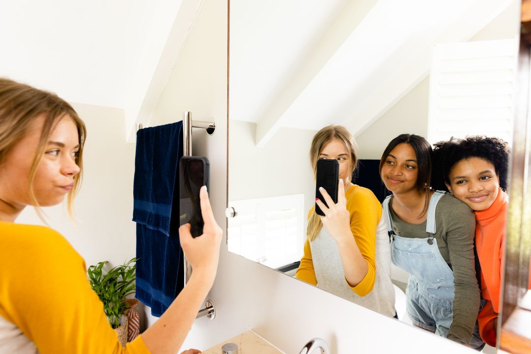 Diverse Teenage Girls Taking Selfie in Bathroom Mirror - Free Images, Stock Photos and Pictures on Pikwizard.com