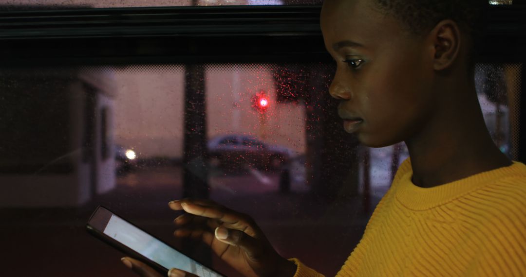 Teenager Using Tablet with Focus on Device Screen on Evening Bus Ride - Free Images, Stock Photos and Pictures on Pikwizard.com