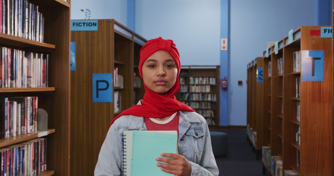 Young Muslim Student Holding Notebook in Library - Free Images, Stock Photos and Pictures on Pikwizard.com