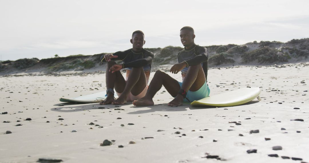 Friends Relaxing with Surfboards on Sandy Beach - Free Images, Stock Photos and Pictures on Pikwizard.com